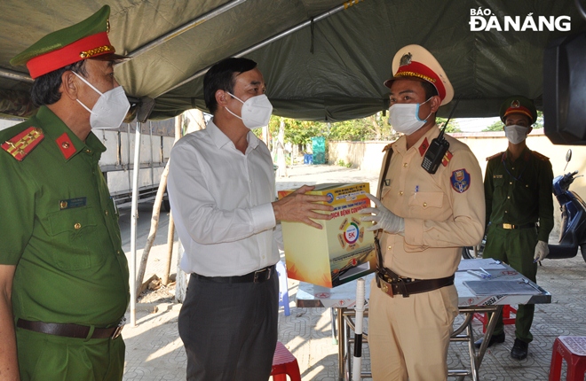 Da Nang Chairman People's Committee Chairman Le Trung Chinh (second from left) presents gifts to the forces on duty at a checkpoint set up on Hoang Van Thai route. Photo: LE HUNG