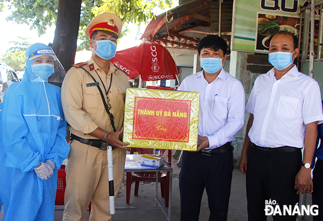 Ủy viên dự khuyết Trung ương Đảng, Phó Bí thư Thường trực Thành ủy, Chủ tịch HĐND thành phố Lương Nguyễn Minh Triết (thứ hai, phải sang) tặng quà động viên các lực lượng làm nhiệm vụ tại chốt Quốc lộ 14B (gần quán Dê 89, huyện Hòa Vang) sáng 30-5. Ảnh: XUÂN DŨNG