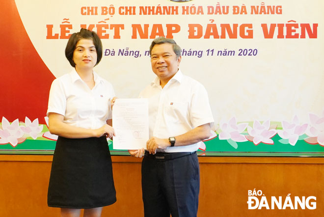Chi bộ Chi nhánh Hóa dầu Đà Nẵng, trực thuộc Đảng bộ Khu Công nghệ cao và các khu công nghiệp Đà Nẵng trao quyết định kết nạp Đảng cho đảng viên mới (bìa trái). (Ảnh chụp tháng 11-2020)Ảnh: MINH SƠN