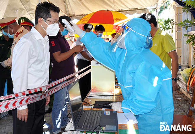  Da Nang Party Committee Secretary Nguyen Van Quang has his body temperature measured at a checkpoint set up at the end point of Tran Dai Nghia Street in Ngu Hanh Son District’s Hoa Hai Ward, May 30, 2021. Photo: LE HUNG