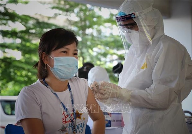 A medical worker is giving COVID-19 vaccination to a woman (Photo: VNA)