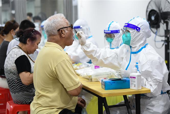 Nhân viên y tế lấy mẫu xét nghiệm COVID-19 cho người dân tại Quảng Châu, tỉnh Quảng Đông, Trung Quốc ngày 26/5/2021. Ảnh: THX/TTXVN