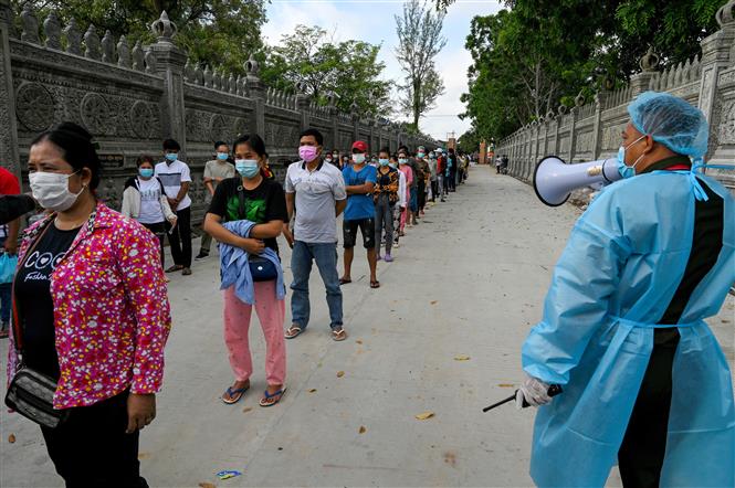 Binh sĩ quân đội Campuchia hướng dẫn người dân giữ khoảng cách phòng lây nhiễm COVID-19 tại một điểm tiêm chủng ở Phnom Penh. Ảnh: AFP/TTXVN