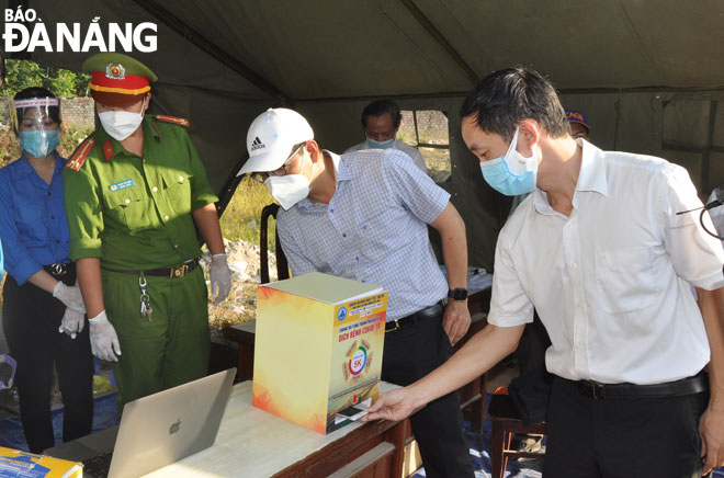 People must complete an online health declaration form to obtain a QR code to show on arrival in Da Nang. Picture is taken at a checkpoint in the extended Nguyen Tat Thanh route. Photo: LE HUNG