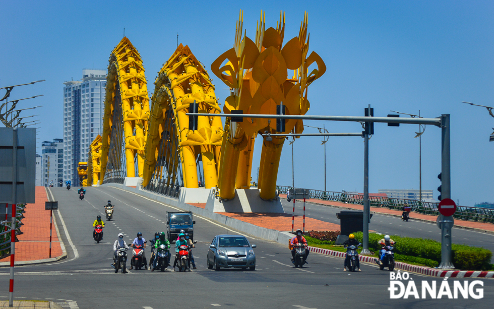  Many residents are advised against going outside if not necessary. Road users are seen at the western end of the ‘Rong’ (Dragon) Bridge under the unpleasant sunlight. Photo: XUAN SON