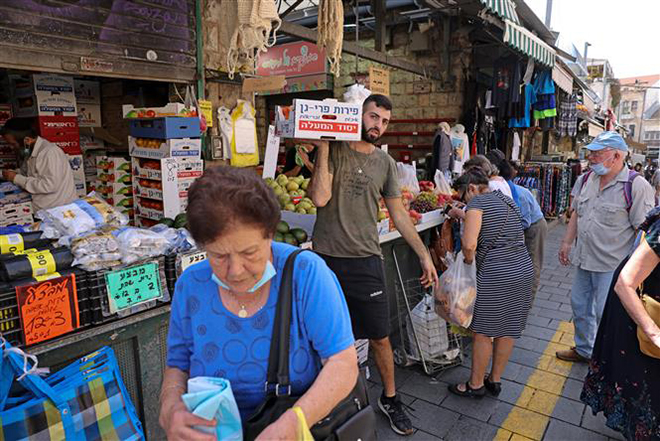 Người dân mua bán tại một chợ ở Jerusalem ngày 1-6-2021. Ảnh: AFP/TTXVN