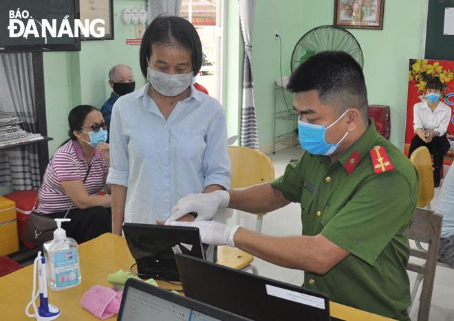  Ngu Hanh Son District police are seen taking fingerprint samples of citizens