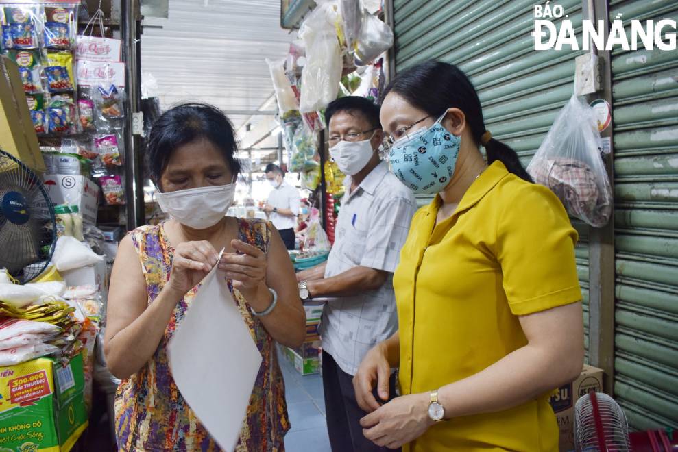 Ms. Phan Thi Thang Loi, Hai Chau District People's Committee Vice Chairman (right) instruct a stall holder on how to label QR codes on products, June 2, 2021. Photo: QUYNH TRANG