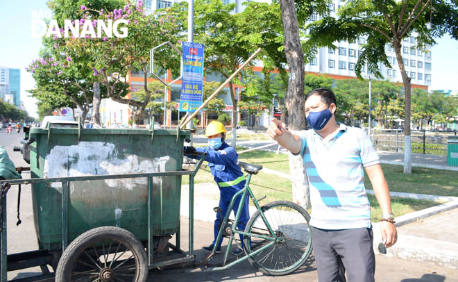 Anh Nguyễn Vũ Hải (phải) đi kiểm tra, đôn đốc công nhân làm việc mỗi ngày, góp phần giữ gìn vệ sinh môi trường. Ảnh: NHẬT HẠ