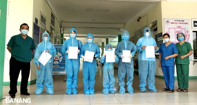 Doctor Le Thanh Phuc, Director of the Da Nang Lung Hospital (left) and the recovered patients pose for a photograph before they leave the hospital.