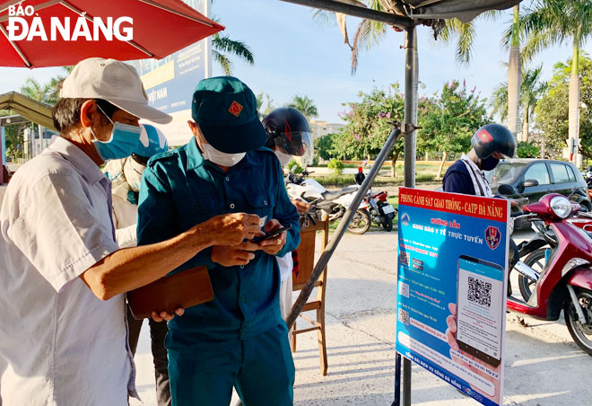  Functional forces support road users to make electronic medical declarations and scan QR codes at a checkpoint on Tran Dai Nghia Street, Ngu Hanh Son District. Photo: K.NINH