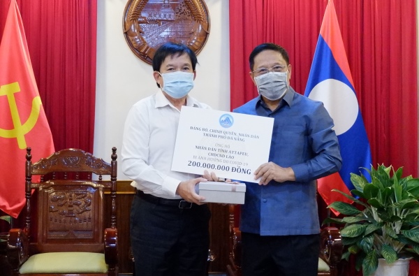 On behalf of the Da Nang government and people, Director of the municipal Department of Foreign Affairs Huynh Duc Truong (left) presents the symbolic board of the donations to the preventative of the Lao Consulate General of Laos in Da Nang