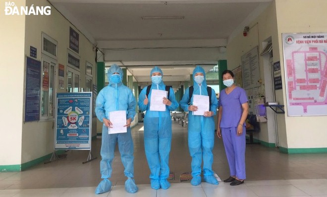 Lãnh đạo Bệnh viện Phổi Đà Nẵng (bìa phải) trao giấy xuất viện cho 3 bệnh nhân mắc Covid-19 được điều trị khỏi. Ảnh: L.H