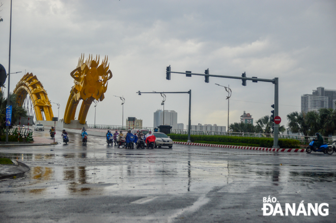 A few road users are seen passing through a traffic intersection at the western end of the ‘Rong’ (Dragon) Bridge.