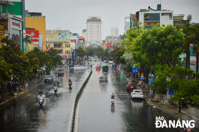 The rain drizzls down onto the intersection of Le Duan, Ly Thai To and Dien Bien Phu streets