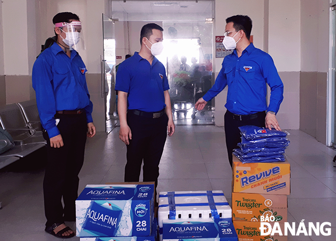 Municipal Youth Union Secretary Nguyen Manh Dung (right) presents gifts for youth union members of Thanh Khe District who are staffing at a COVID-19 checkpoint in the Da Nang Railway Station on Saturday morning. Photo: T.S