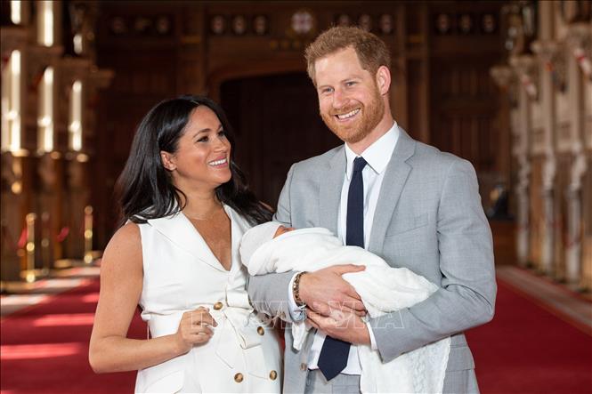 Hoàng tử Anh Harry (phải) và vợ, nữ Công tước xứ Sussex, Meghan Markle cùng bé trai mới sinh được đặt tên Archie Harrison Mountbatten-Windsor tại Lâu đài Windsor, phía Tây London (Anh) ngày 8/5/2019. Ảnh tư liệu: AFP/TTXVN