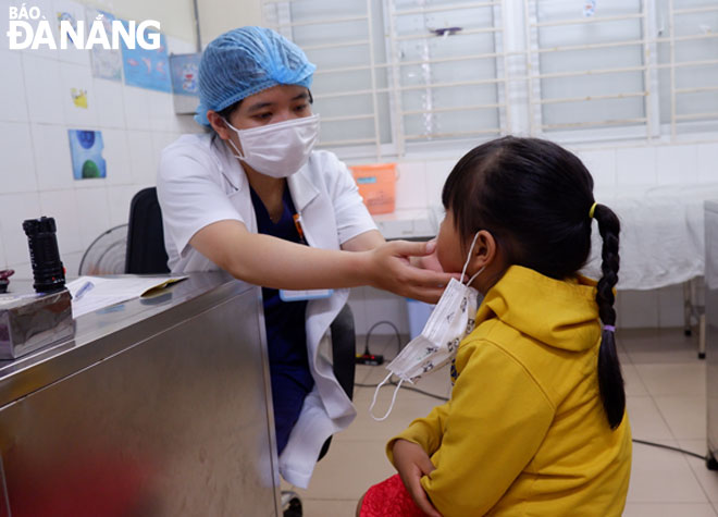 Bác sĩ đang khám cho bệnh nhi tại Bệnh viện Phụ sản-Nhi Đà Nẵng.       						          Ảnh: PHAN CHUNG