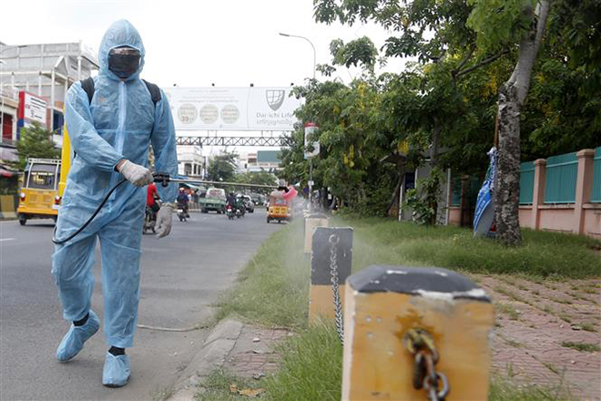 Nhân viên y tế phun thuốc khử trùng nhằm ngăn chặn sự lây lan của Covid-19 tại Phnom Penh, Campuchia, ngày 9-5-2021. Ảnh: THX/ TTXVN