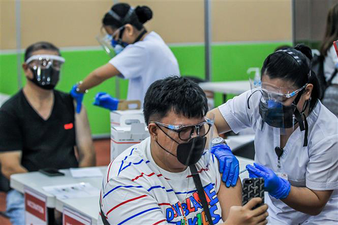 Nhân viên y tế tiêm vaccine phòng Covid-19 cho người dân tại Manila, Philippines, ngày 12-5-2021. Ảnh: THX/ TTXVN