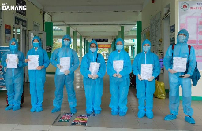 The recovered patients pose for a photo before leaving the Da Nang Lung Hospital.