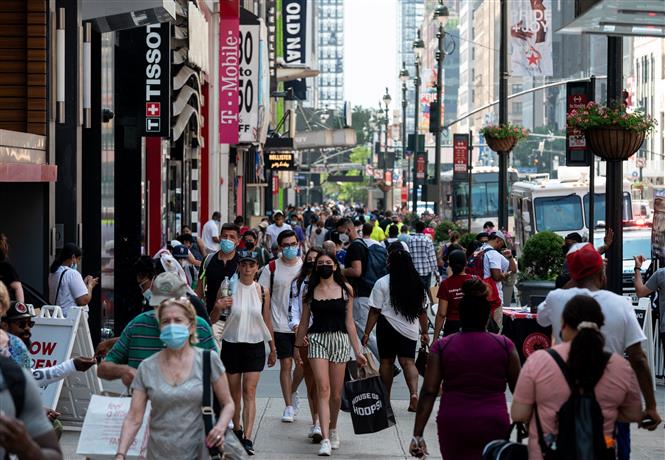 Người dân di chuyển trên một tuyến phố mua sắm ở New York, Mỹ ngày 7/6/2021. Ảnh: AFP/TTXVN