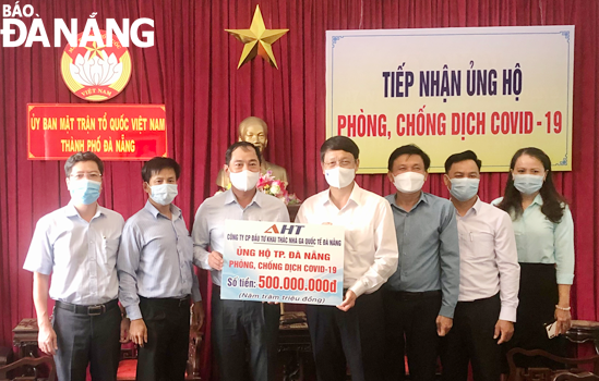 Chairman of the Da Nang Committee of VFF Ngo Xuan Thang (middle) receives the symbolic board of the donations from the Da Nang International Terminal Investment and Operation Joint Stock Company (AHT), June 8, 2021