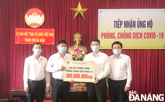 Chairman of the Da Nang Committee of VFF Ngo Xuan Thang (second from right) receives a symbolic board of donations worth VND 300 million from the Da Nang Port JSC