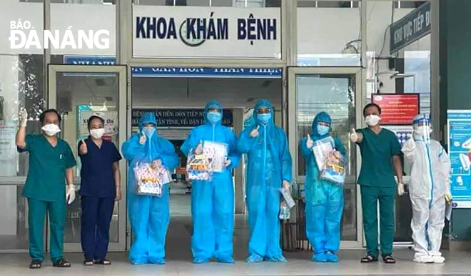 Da Nang has recorded 21 days without local transmission that is very important to Da Nang to lift restrictions on certain essential activities in a bid to meet the desire and aspiration of the public across the city after a lengthy battle with COVID-19. In photo: Leaders of the Hoa Vang Medical Centre and the four recoveries pose for a photograph. 
