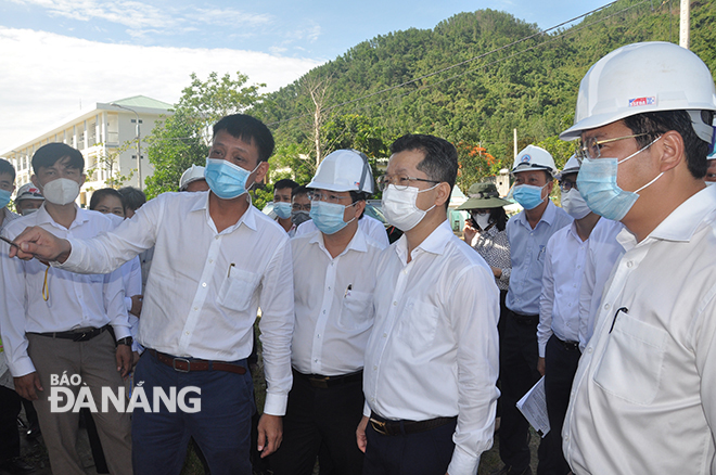 Da Nang Party Committee Secretary Nguyen Van Quang (4th, left) listens to leaders of Hoa Vang District reporting the progress of the central resettlement area project in Hoa Bac commune. Photo: THANH LAN