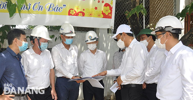 Secretary Quang (4th, left) listens to construction units reporting on a project to upgrade both approaches to Truong Dinh Bridge. Photo: THANH LAN