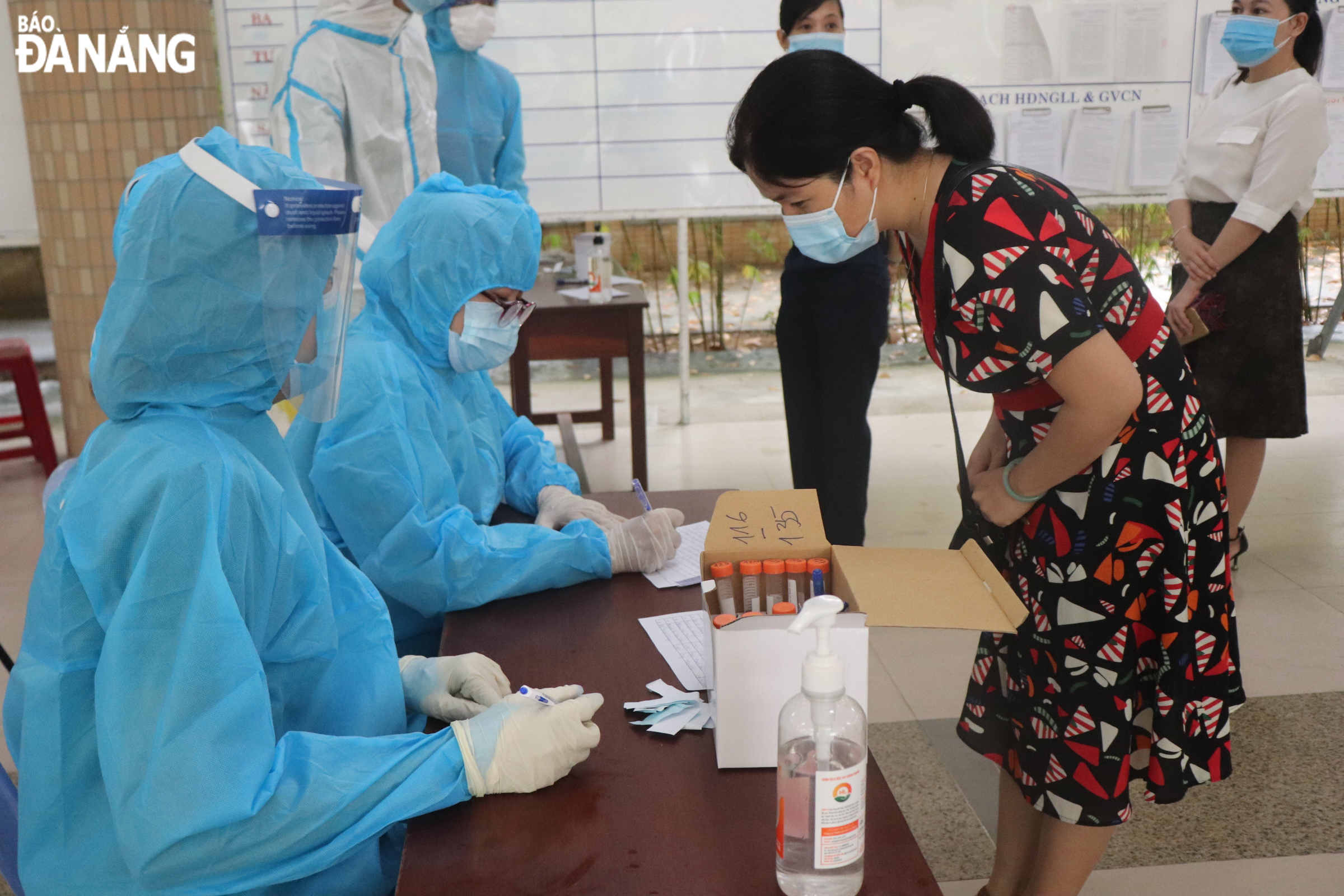 Medical workers collect personal information from those who get tested for COVID-19. Photo: NGOC HA