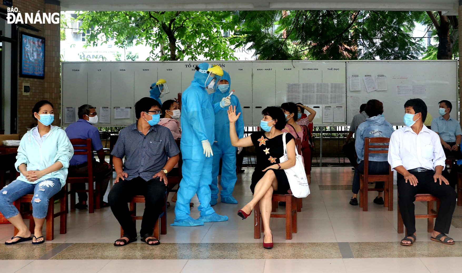 People sit to wait for their turns to have their swabs taken . Photo: NGOC HA