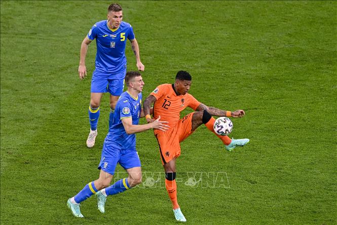 Pha tranh bóng quyết liệt giữa hậu vệ Hà Lan Patrick van Aanholt (phải) và các cầu thủ Ukraine trong trận đấu vòng chung kết EURO 2020 trên sân ở Amsterdam, ngày 13-6-2021. Ảnh: AFP/TTXVN