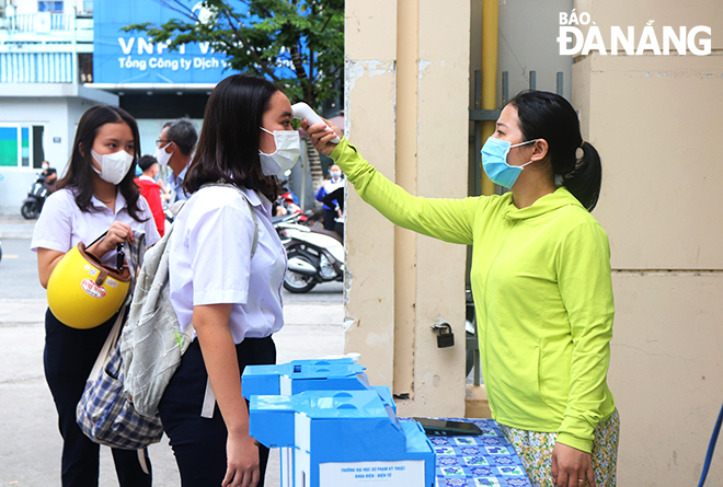 The functional force measures the body temperature of candidates who will sit for the upcoming 10th-grade entrance exams for the 2021-2022 school year before the sampling at the Tran Phu Senior High School, one of the city’s concentrated exam venues, June 13, 2021.