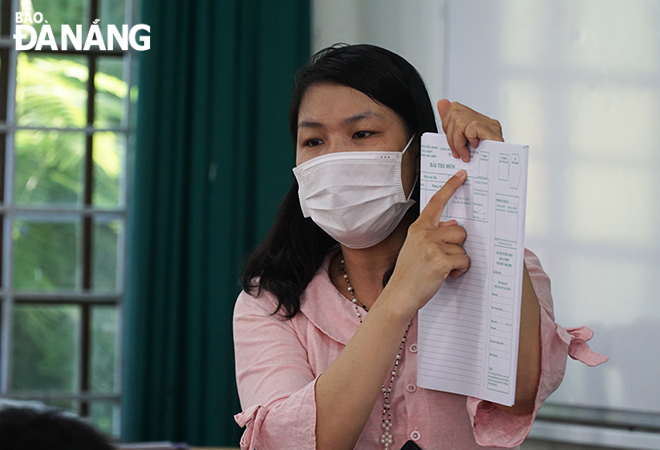 A examination invigilator guides candidates to fill in the information before taking their test. Photo: XUAN DUNG