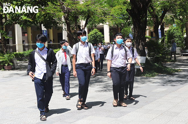 Các thí sinh tại điểm thi Trường THPT Trần Phú bước ra ngoài sau khi hoàn thành xong môn thi Ngữ văn sáng 15-6. Ảnh