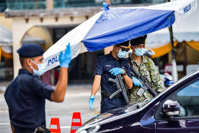 Cảnh sát và binh sĩ kiểm tra các phương tiện để phòng dịch Covid-19 tại Kuala Lumpur, Malaysia, ngày 1-6-2021. Ảnh: THX/ TTXVN