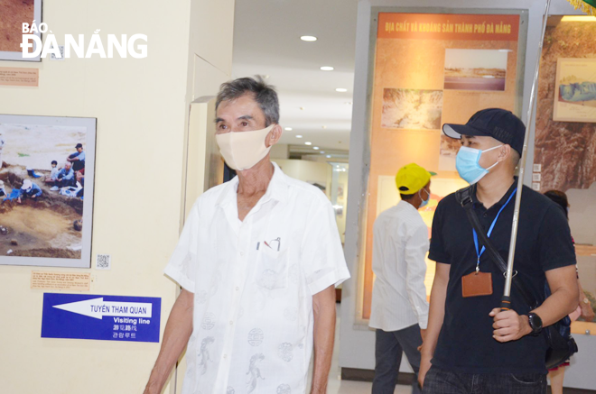 A tour guide (right cover) takes his guests to the Museum of Da Nang, April, 2021. Photo: THU HA