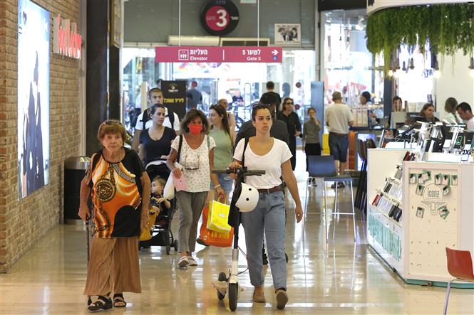 Người dân không phải bắt buộc đeo khẩu trang tại một trung tâm mua sắm ở Tel Aviv, Israel, ngày 15/6/2021. Ảnh: AFP/TTXVN