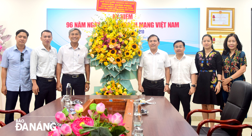 Deputy Head of the T26 Administration Department Nguyen Thanh Tung (third from left), authorised President Nguyen Xuan Phuc, presents the congratulatory bouquet to the Da Nang Newspaper, June 17, 2021.