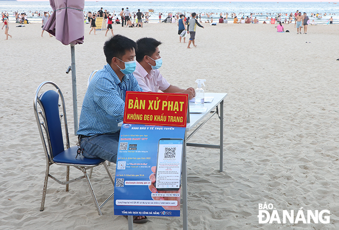 Security guards staffing at entry points to the beach tighten monitoring of beach visitors to make sure every one is adhering to the COVID-19 prevention measures. Photo: VAN HOANG