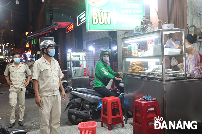 The functional forces in Vinh Trung Ward, Thanh Khe District patrol, monitor and check the compliance of prevention measures among food and drink shops on Hung Vuong Street in the evening of June 16. Photo: MINH LE