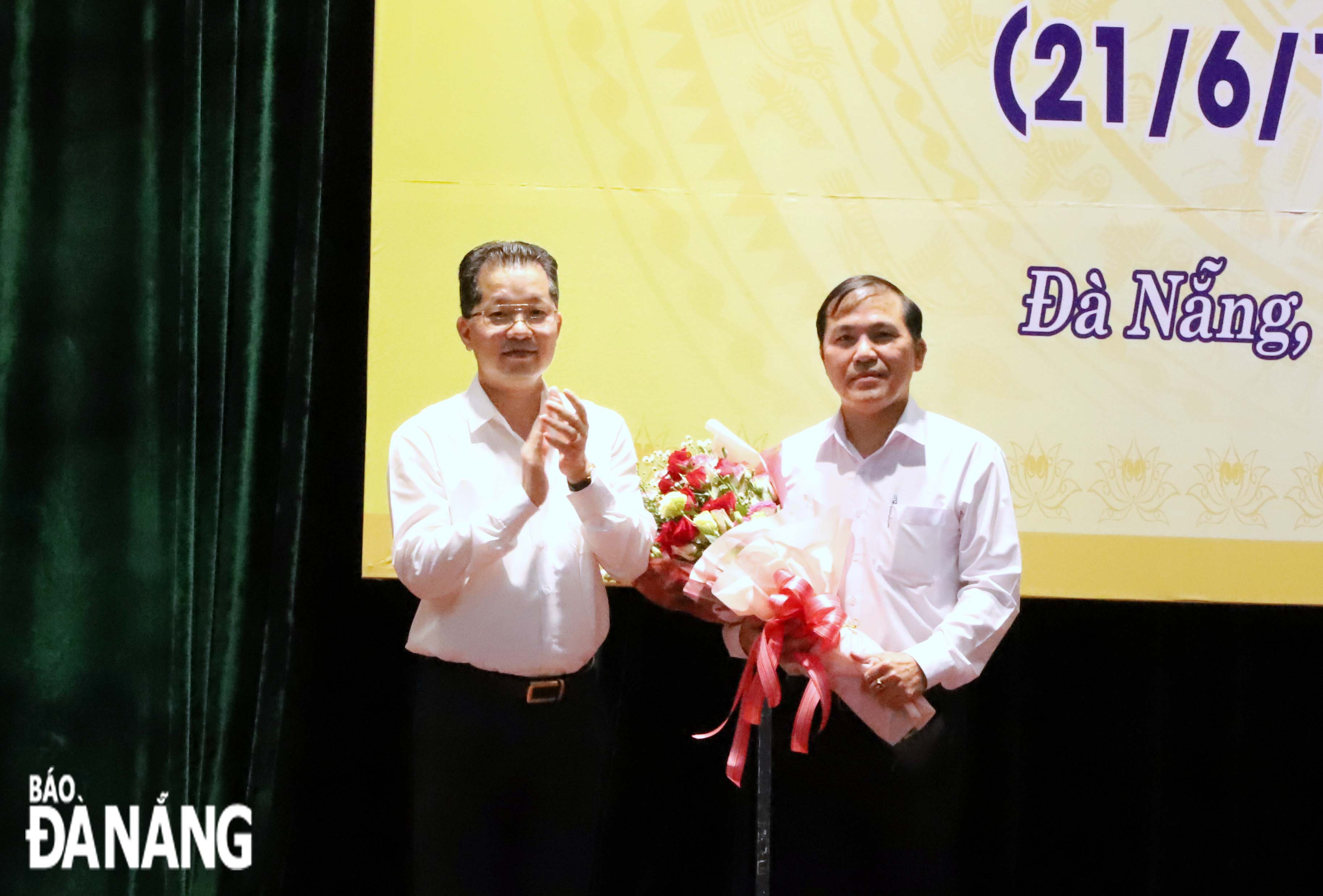 On behalf of the city's press force, Mr. Nguyen Duc Nam, Chairman of the municipal Journalists’ Association cum Editor-in-Chief of the Da Nang Newspaper (right) receives congratulatory flowers from Da Nang Party Committee Secretary Nguyen Van Quang, June 18, 2021. Photo: NGOC PHU.