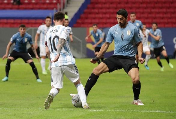 Messi với pha đi bóng vượt qua tiền đạo Luis Suarez (Uruguay). (Nguồn: Reuters)