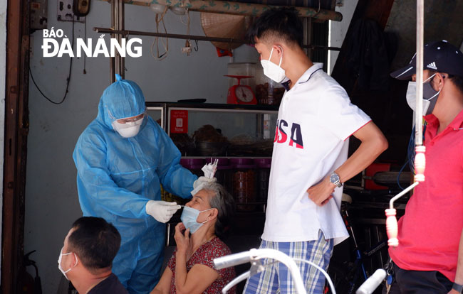 Da Nang medical staff take swab samples from residents in Thanh Khe District for COVID-19 testing. Photo: PHAN CHUNG