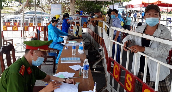   Functional forces guide drivers, their assistants and passengers to declare their health status at a checkpoint on the National Highway 1A in Hoa Phuoc Commune.