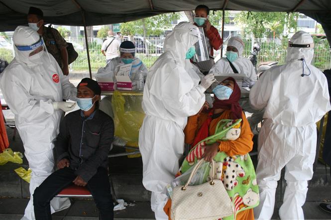 Nhân viên y tế lấy mẫu xét nghiệm Covid-19 cho người dân tại Surabaya, Đông Java, Indonesia. Ảnh: THX/TTXVN