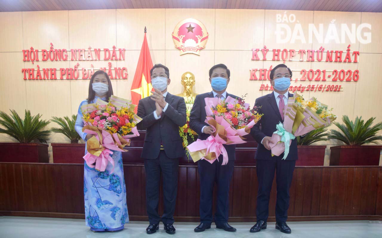 Da Nang Party Committee Secretary Nguyen Van Quang (second, left) presents flowers to congratulate Mr Luong Nguyen Minh Triet (second, right), Le Minh Trung (first, right) and Cao Thi Huyen Tran (first, left) on their new positions. Photo: TRONG HUY