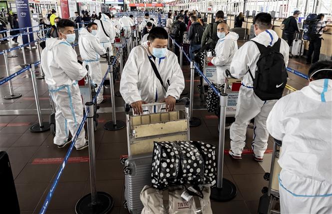 Hành khách mặc trang phục bảo hộ nhằm ngăn chặn sự lây lan của virus SARS-CoV-2 tại sân bay quốc tế ở Santiago, Chile. Ảnh: AFP/TTXVN